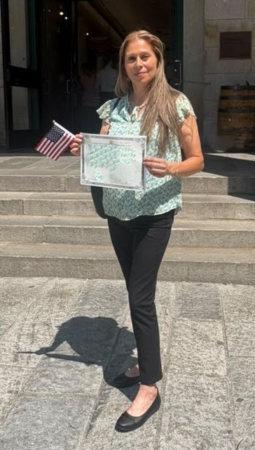 Juana poses with flag and papers.